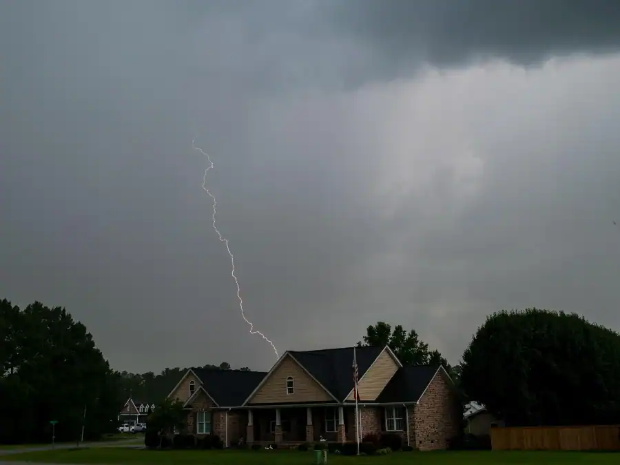 A storm approaching a house, striking lighting near it