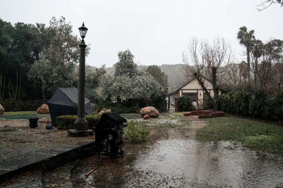 Backyard with standing water showing drainage concerns during severe weather