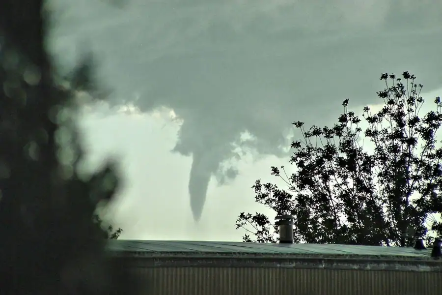 Tornado funnel cloud forming beneath dark storm clouds